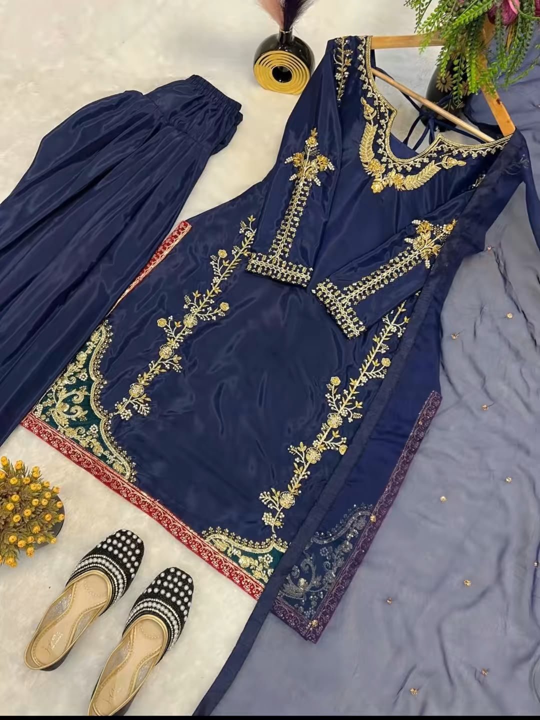 Navy blue embroidered dress with gold floral detailing, matching trousers, and dupatta
